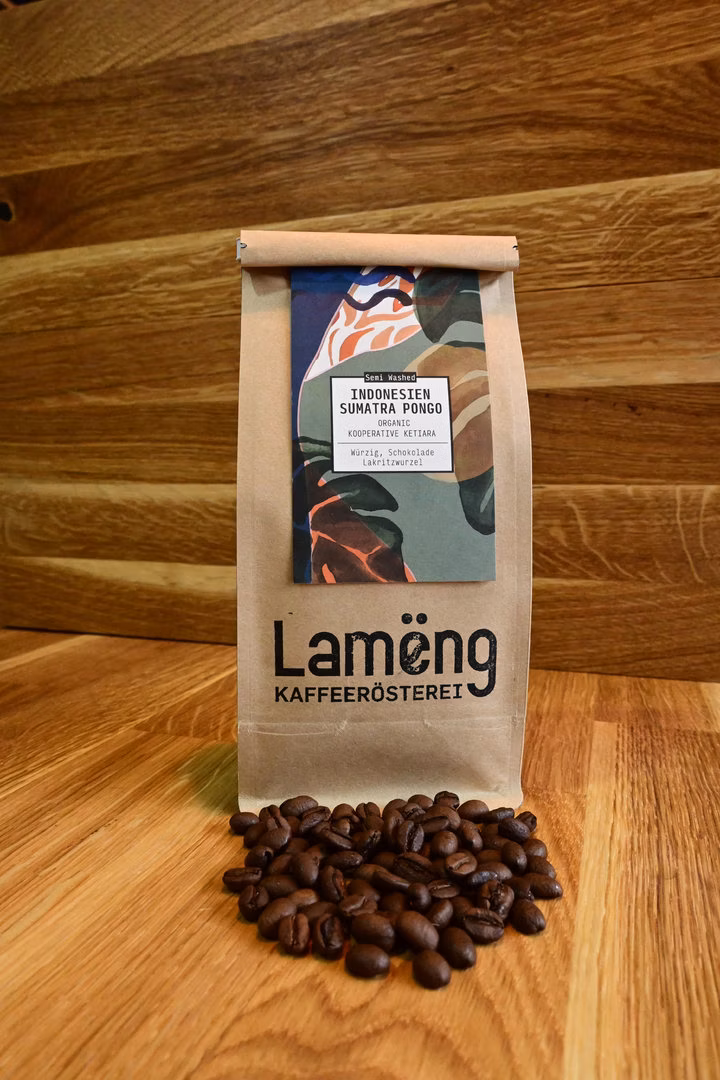Lamëng-Kraftpapier-Tüte mit Sumatra-Pongo-Etikett, davor frisch geröstete Single-Origin-Bohnen aus dem Gayo-Hochland
